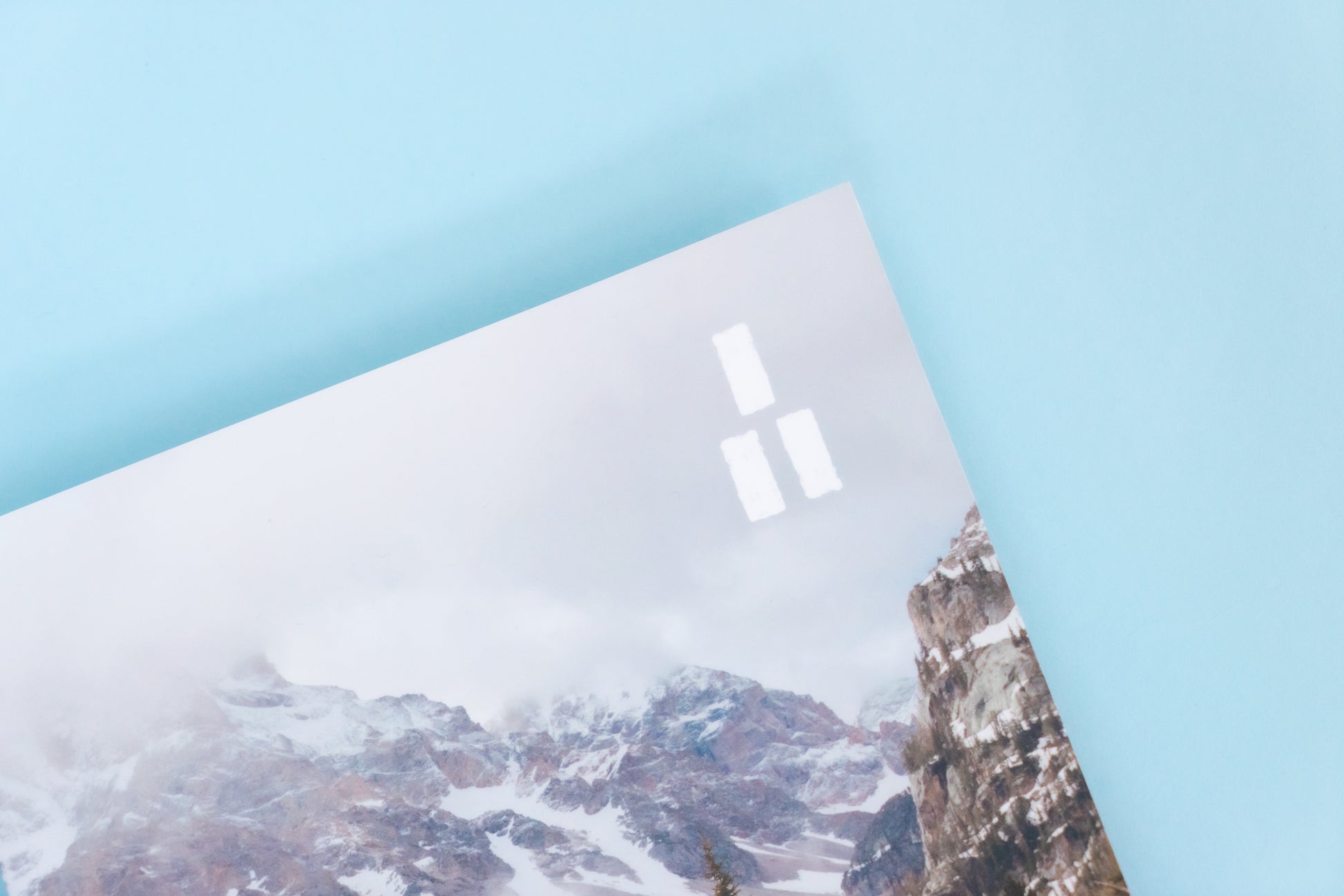 The top right corner of a magazine is visible featuring a cold winter mountain scene and the Trails Magazine logo, three parallel white rectangles stacked into a triangle making a trail market blaze.