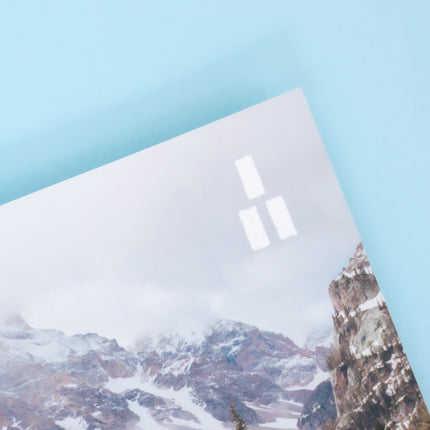 The top right corner of a magazine is visible featuring a cold winter mountain scene and the Trails Magazine logo, three parallel white rectangles stacked into a triangle making a trail market blaze. 