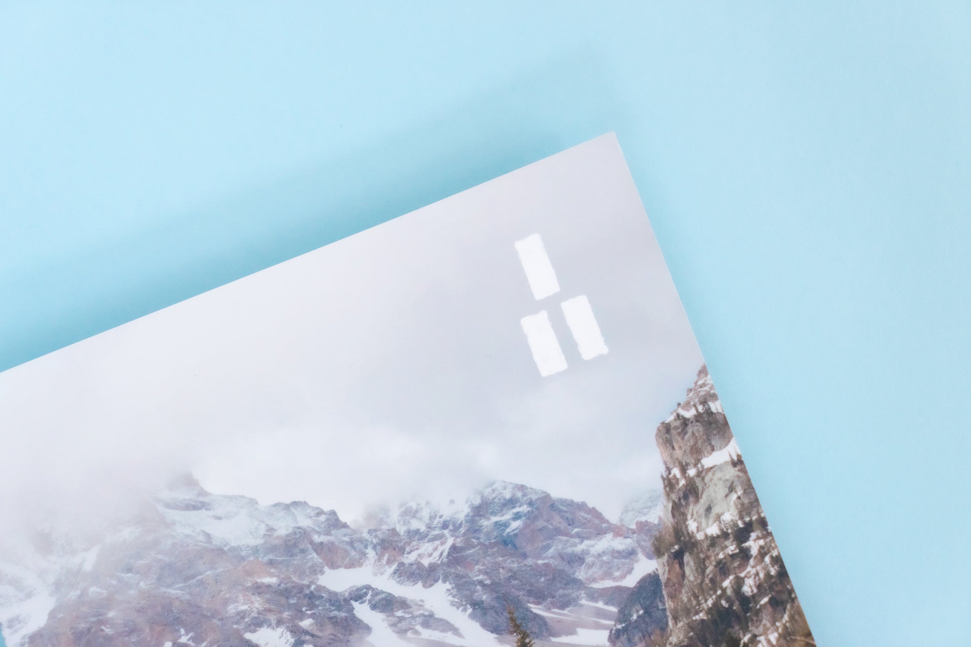 The top right corner of a magazine is visible featuring a cold winter mountain scene and the Trails Magazine logo, three parallel white rectangles stacked into a triangle making a trail market blaze. 