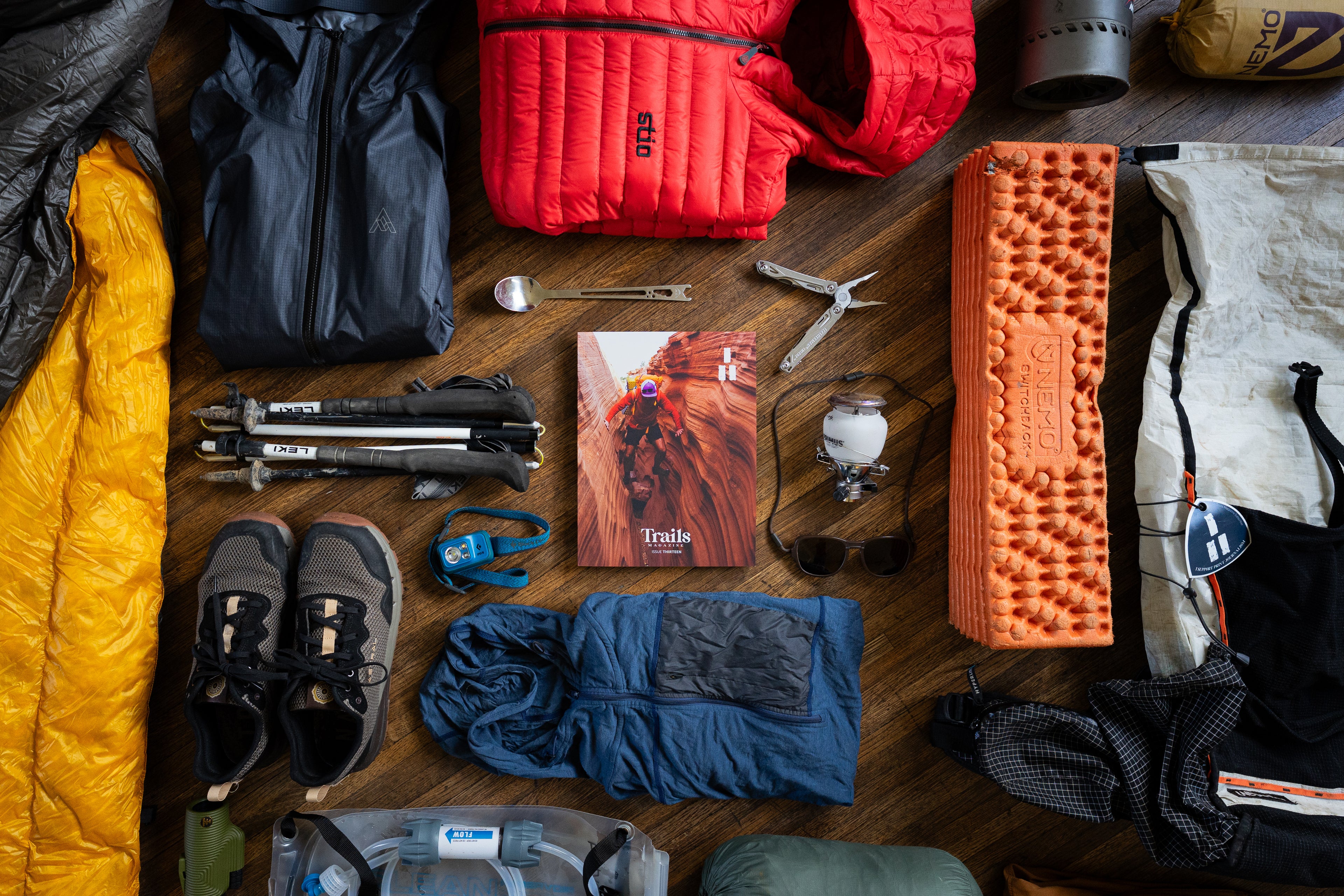 Trails Magazine Issue 13 surrounded by a collection of backpacking gear. 